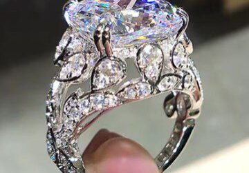 A person is holding onto the ring of diamonds