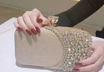 A woman is holding onto the handle of her purse