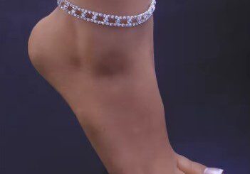 A woman wearing a white anklet with pearls.