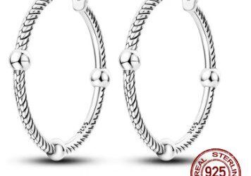 A pair of silver earrings with a number on them.