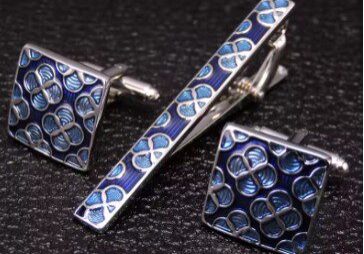 A close up of a tie clip and cufflinks