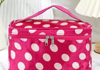A pink polka dot bag sitting on top of a table.