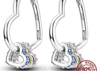 A pair of silver earrings with a heart shaped design.