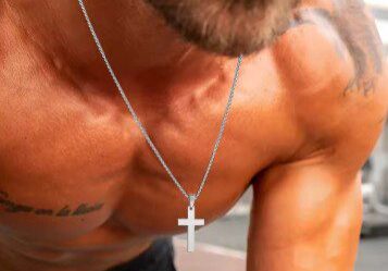 A man with no shirt and without shirt is holding his cross.