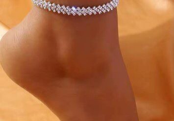 A woman wearing a silver anklet with white stones.