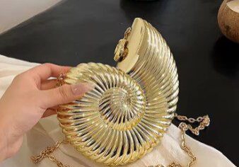A person holding onto the chain of a purse