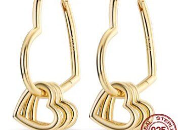 A pair of gold earrings with three hearts hanging from them.