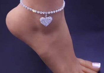 A woman wearing a heart charm on her ankle.