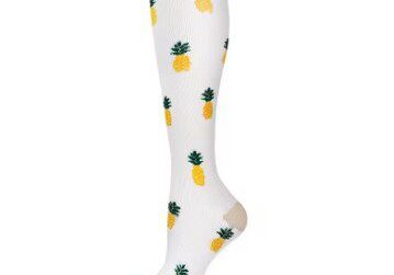 A pair of pineapple socks with green stripes on the bottom.