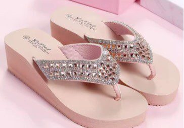 A pair of pink sandals with silver straps.