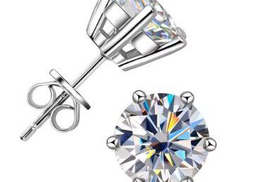 A pair of diamond earrings sitting next to each other.