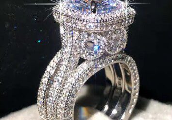 A diamond ring with a large center stone on top of it.
