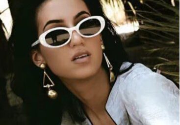 A woman with sunglasses on and wearing white.